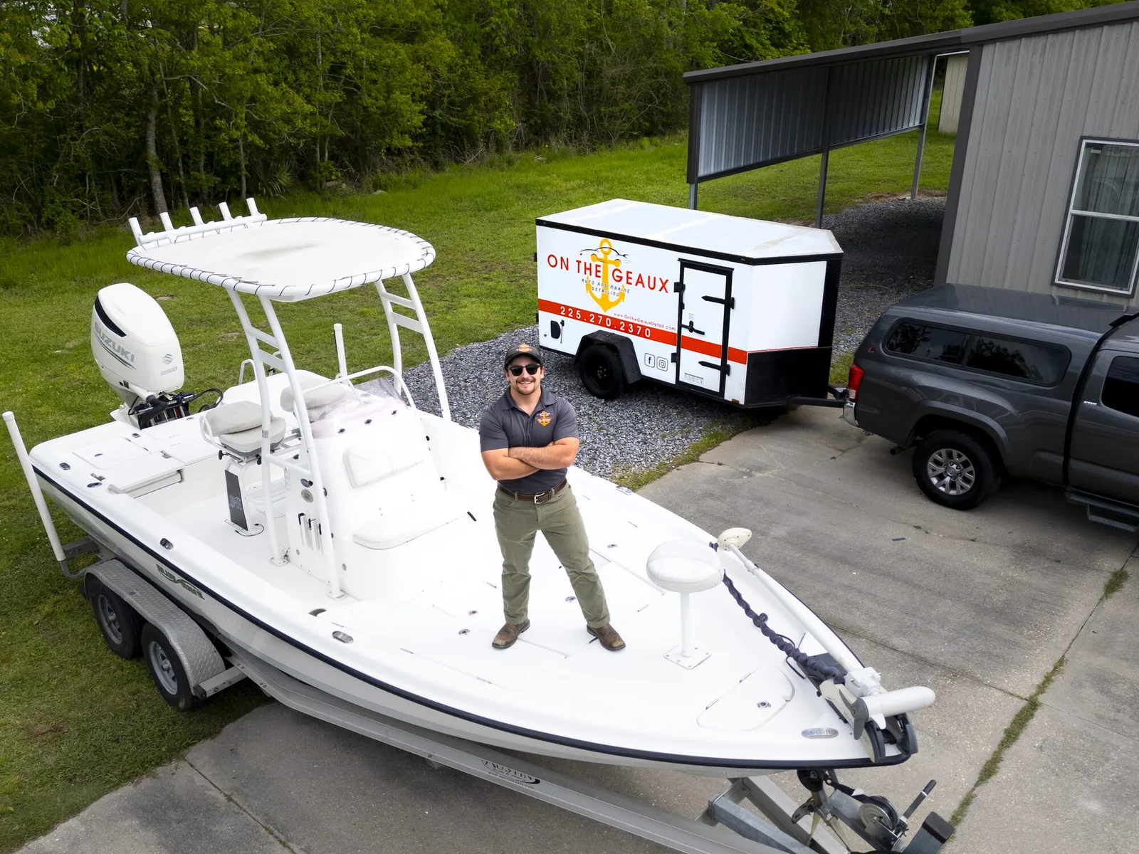Hunter on a clean center-console boat with the service truck and branded trailer nearby.